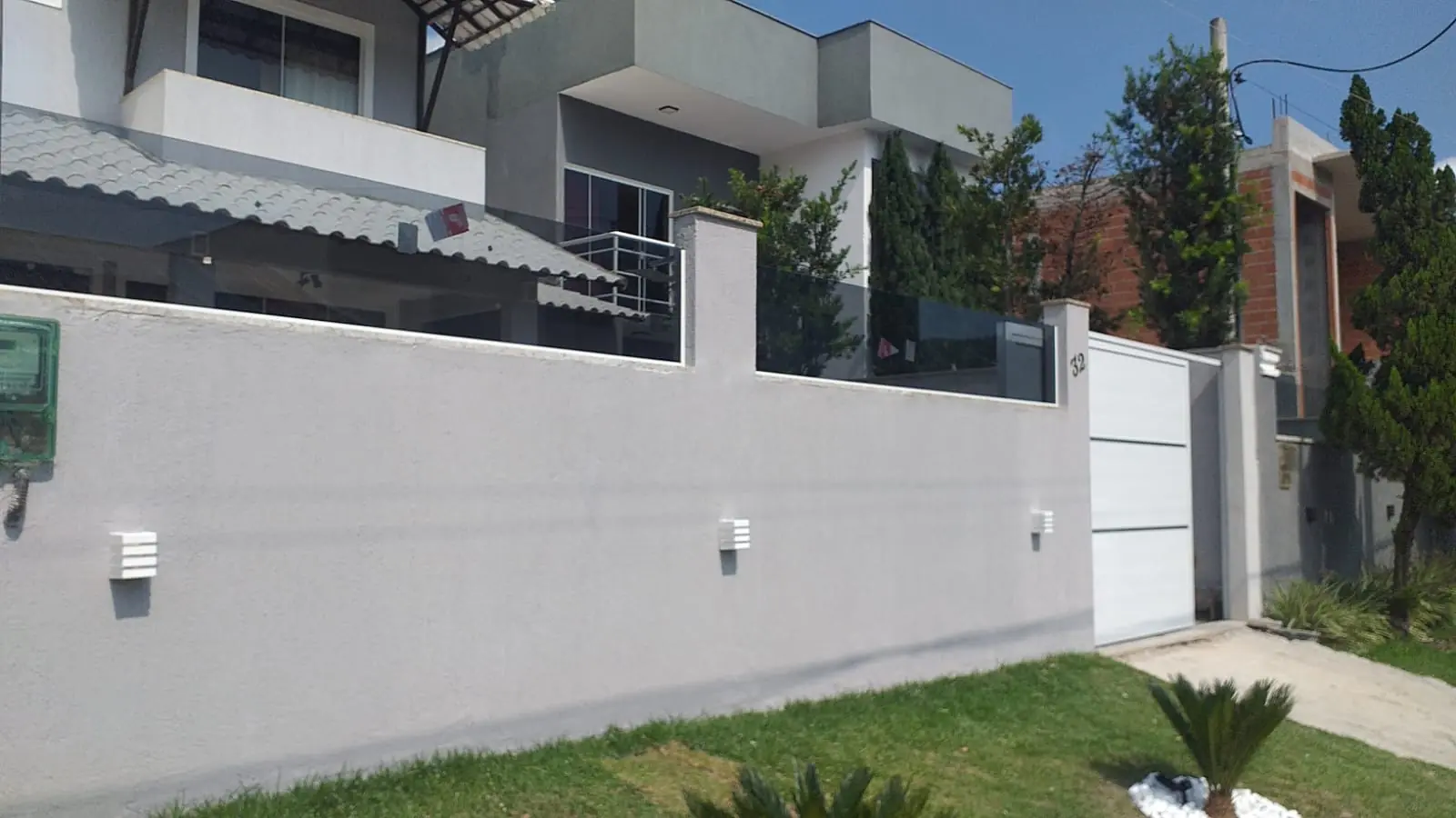 Muro com portão de alumínio branco em residência